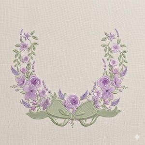 May include: Embroidered floral wreath design featuring lavender, purple, and green hues. The wreath includes roses, lavender sprigs, and a green bow at the bottom. The design is set against a neutral, textured background.