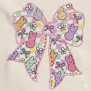 May include: A large, decorative bow with a pastel color scheme. The bow features a checkered pattern with embroidered details of Easter bunnies, flowers, and bows. The bow is outlined in pink and has a stitched appearance.