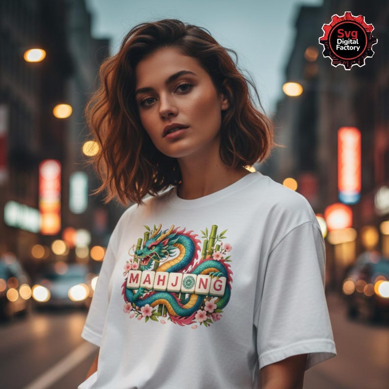 May include: White t-shirt featuring a colorful dragon design with the word "MAHJONG" in tile letters. The dragon is teal, blue, and yellow, surrounded by pink flowers and bamboo. The shirt is worn by a person in an urban setting.
