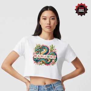 May include: White crop top featuring a colorful graphic of a dragon, bamboo, and flowers with the word "MAHJONG" in a tile font. The design is centered on the front of the shirt.