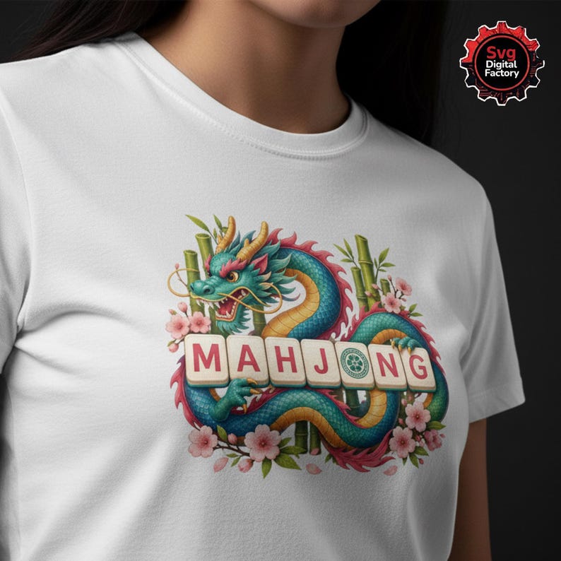 May include: White t-shirt featuring a colorful illustration of a dragon with the word "MAHJONG" in tiles. The dragon is teal, blue, and yellow, surrounded by bamboo and pink flowers. The shirt has a crew neck.