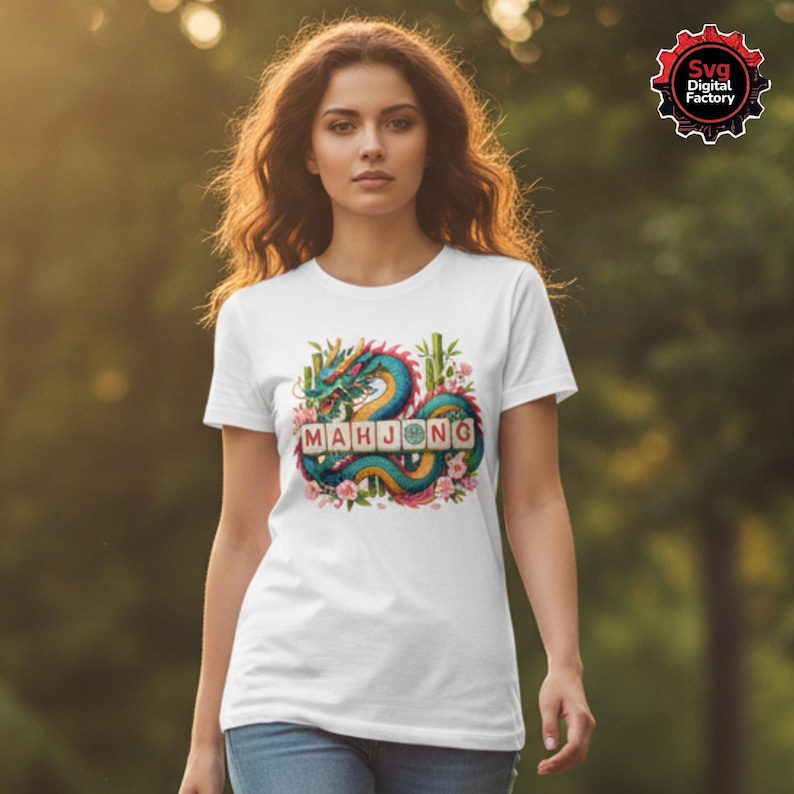 May include: White t-shirt featuring a colorful illustration of a dragon with the word "MAHJONG" in wooden letter tiles. The dragon is teal, blue, and yellow, surrounded by bamboo and pink flowers. The shirt is being worn.