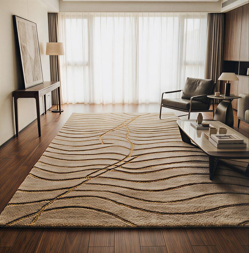 May include: A beige rectangular rug featuring a pattern of brown and gold wavy lines. The rug is placed in a room with hardwood flooring, large windows, and contemporary furniture. The rug's design adds a touch of elegance.