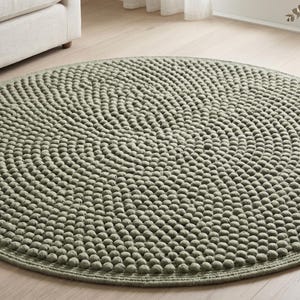 May include: A circular area rug in a muted sage green colour, featuring a dense, textured surface composed of numerous small, raised spherical tufts arranged in concentric circles, finished with a smooth, flat-woven border around the edge.