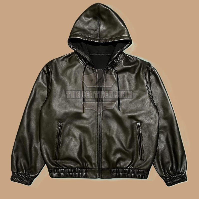 May include: Black leather hooded jacket with a zip closure and two front pockets. The jacket features a drawstring hood and a ribbed hem and cuffs. The text "THE LEATHER SKIN" is visible on the front.