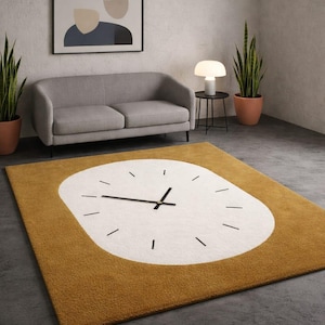 Może przedstawiać: Musztardowo-żółty i biały dywan z tarczą zegara. Dywan ma duży biały owal pośrodku z czarnymi wskazówkami i znacznikami godzin. Dywan jest prostokątny z musztardowo-żółtą obwódką. Dywan znajduje się w salonie.