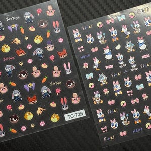 Peut inclure: Deux planches d'autocollants pour nail art avec des personnages de dessins animés de Zootopie et Disney. Les autocollants comprennent des images de Judy Hopps, Nick Wilde et Daisy Duck, ainsi que le texte "Fine!" et "Hello". La planche d'autocollants est étiquetée "TC-726".