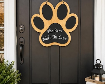 Letrero de madera con forma de huella de pata para colgar en la puerta: "Las patas hacen las leyes".