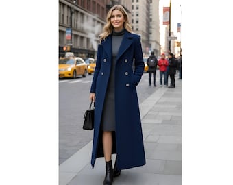 May include: A long, navy blue double-breasted coat with gold buttons. The coat is worn over a gray dress and paired with black boots and a black handbag. The background shows a city street with yellow taxis and pedestrians.