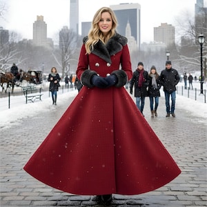 May include: A long, red coat with a flared skirt, black fur collar, and dark blue gloves. The coat has large, silver buttons and is worn in a snowy outdoor setting with people in the background.
