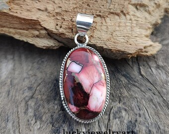 May include: Oval pendant with a silver bail and a composite stone. The stone features a mix of red, pink, white, and gold colours. The pendant is set in a silver rope-style bezel. The text "luckyjewelryart" is at the bottom.