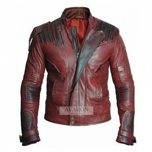 Puede incluir: Chaqueta de cuero burdeos con cuello alzado y cremallera asimétrica. La chaqueta presenta detalles negros en los hombros y las mangas, con detalles acanalados en los codos. La marca "AVARON JACKETS" es visible.