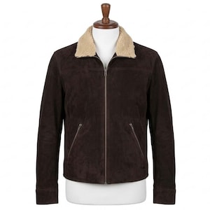 Puede incluir: Chaqueta de ante marrón oscuro con cuello de piel sintética beige, expuesta en un maniquí. La chaqueta tiene cremallera frontal, dos bolsillos delanteros y mangas largas. Una prenda de abrigo clásica.