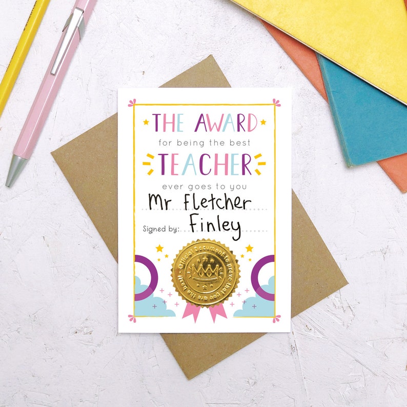May include: A white card with a gold star and the text "THE AWARD for being the best TEACHER ever goes to you Mr Fletcher. Signed by: Finley". The card has a gold seal with a crown and the text "Official Document to prove you are the best teacher ever!"
