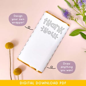 May include: A white candy bar wrapper with the words "Thank You" in a playful font. The wrapper has a gold border and is surrounded by purple and yellow flowers. Text on the image says "Design your own wrapper!" and "Draw anything you want."