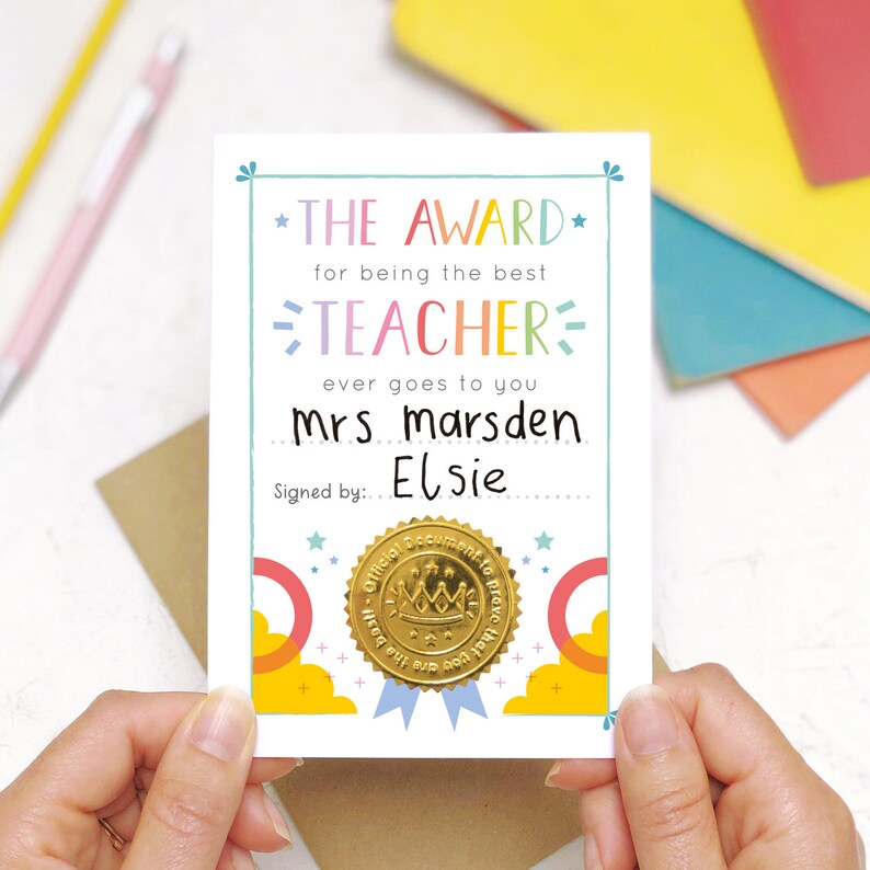 May include: A colorful card with a gold seal that reads "Official Document to prove that" with a crown on top. The card says "The Award for being the best Teacher ever goes to you Mrs Marsden Signed by: Elsie"