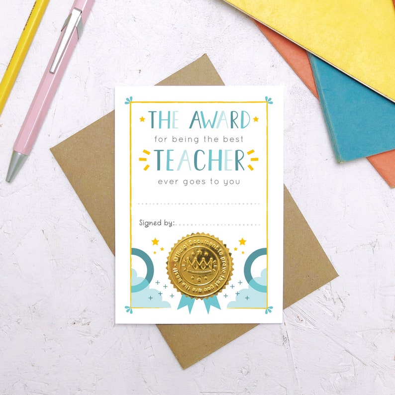 May include: A light blue and white card with a gold foil seal. The card reads "The Award for being the best Teacher ever goes to you."  The card has a space for a signature and a gold foil seal with a crown and the words "Official  Acknowledgement to make you feel good about you".