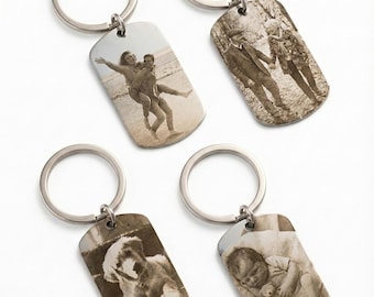 May include: Four metal keychains with silver rings. Each keychain has a rectangular tag with a sepia-toned image. The images include a couple, a group of people, a dog, and a baby.