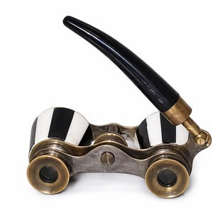 May include: Antique opera glasses with a black handle and brass accents. The lenses are framed in a silver-toned metal, and the eyepieces feature a black and white striped design. A classic accessory for theater or events.
