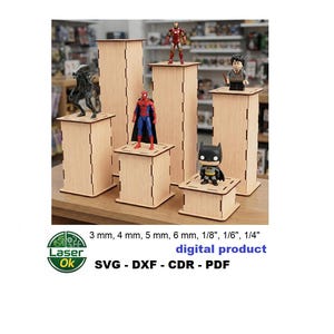 Puede incluir: Expositores de madera de diferentes alturas, que muestran figuras de superhéroes y personajes de la cultura pop. Los expositores son de madera clara y presentan un diseño ranurado. El texto en la imagen dice: 3 mm, 4 mm, 5 mm, 6 mm, 1/8", 1/6", 1/4", producto digital, SVG - DXF - CDR - PDF.