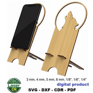 Può includere: Supporto per telefono in legno chiaro con un lupo che ulula intagliato. Il supporto sostiene uno smartphone nero in posizione verticale. L'immagine include anche il testo "digital product".