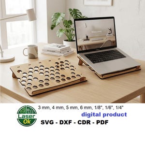 May include: A light-colored wooden laptop stand featuring a geometric honeycomb cutout pattern. The stand is shown in two pieces, one supporting a silver laptop. Text includes 3 mm, 4 mm, 5 mm, 6 mm, 1/8 inch, 1/6 inch, 1/4 inch, digital product, SVG, DXF, CDR, PDF.