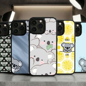 May include: A collection of phone cases with various koala designs. One case features a pattern of koala faces and hearts, while others showcase koalas with leaves, a koala with the text "KOALA LOVE", and a koala on a blue background.
