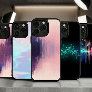 May include: A collection of five black phone cases with unique designs. The cases feature abstract patterns in shades of pink, purple, and blue, as well as graphic representations of sound waves in green and multicolored hues. The cases are displayed on a gray surface.