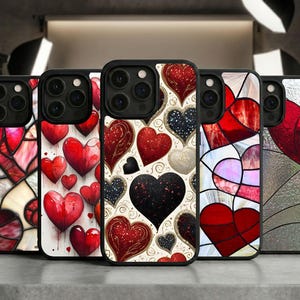 May include: A collection of five phone cases with heart designs. The cases feature various patterns, including stained glass, watercolor hearts, and textured hearts in red, black, and white. Each case has a black border.