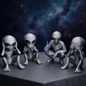 May include: Four grey alien figurines in a row. The first covers its ears, the second covers its mouth, the third holds a small blue bottle, and the fourth covers its eyes. Each figure has a smooth, metallic finish and large, dark, oval eyes.