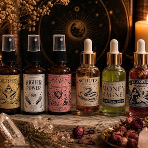 Könnte beinhalten: Sechs Glasflaschen mit rituellen Ölen und Sprays von Cosmolita. Drei bernsteinfarbene Sprühflaschen mit den Etiketten Schutzspray, Higher Power und Komm Zu Mir. Drei klare Pipettenflaschen mit den Etiketten Schutz, Money Magnet und Glamour, je 30 ml.