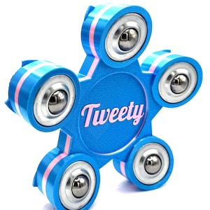 Puede incluir: Un spinner azul en forma de estrella. Tiene cinco secciones redondeadas con rodamientos de bolas plateados. Cada sección está acentuada con rayas rosas. La palabra "Tweety" está impresa en rosa en el centro.