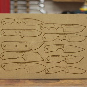 Könnte beinhalten: Eine beige Platte mit geätzten Umrissen verschiedener Messer. Die Designs umfassen verschiedene Klingen- und Griffformen. Auf jeder Messerumriss ist der Text "dig-knives.de" aufgedruckt.