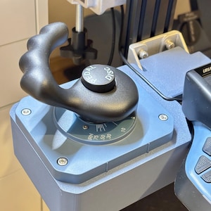 Könnte beinhalten: Ein schwarzer ergonomischer Steuergriff mit geschwungenem Griff, montiert auf einer hellblauen Basis. Der Griff verfügt über ein kreisförmiges Oberteil mit der Aufschrift PEDAL DISC und ein Einstellrad mit Markierungen wie 30, 50, 75 und RH.