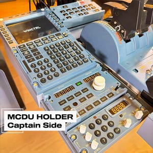 Könnte beinhalten: Ein hellblaues Flugsimulator-Bedienfeld mit einem MCDU, dessen Bildschirm WINCTRL anzeigt, sowie einem Ziffernblock und verschiedenen Funktionstasten. Darunter befindet sich ein Funkmanagement-Panel mit Digitalanzeigen, Drehknöpfen und Schaltern.