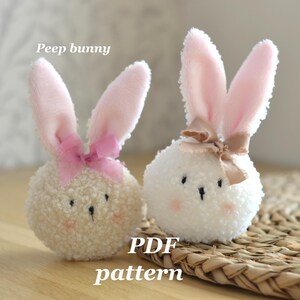 May include: Two plush bunny figures with pink ears and bows. One bunny is cream-colored with a pink bow, the other is white with a tan bow. The text "Peep bunny" and "PDF pattern" are visible.