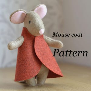 May include: A stuffed mouse wearing a rust-colored felt coat. The mouse has tan fur, pink ears, and a pink nose. The text "Mouse coat Pattern" is written in black on the right side of the image.