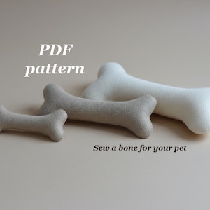 Op de afbeelding: Afbeelding van drie pluche hondenbotten in verschillende maten. De botten zijn in tinten beige en wit, met de tekst "PDF pattern" en "Sew a bone for your pet".