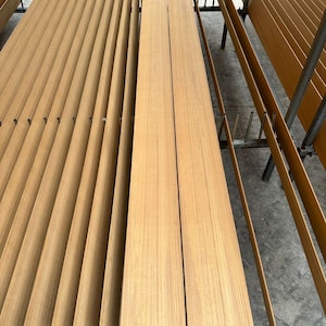 Op de afbeelding: Verschillende lichtbruine houten planken, sommige verticaal en andere horizontaal gerangschikt, wat wijst op een houtbewerkingsproject. De planken hebben een gladde nerf, wat suggereert dat ze bedoeld zijn voor constructie of meubelmakerij.