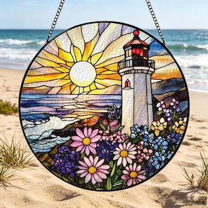 May include: Circular stained glass window depicting a coastal scene with a lighthouse. The artwork showcases a yellow sun, blue sea, and vibrant flowers. The lighthouse is white with a red light, and the window is framed with a black metal chain.