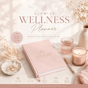 May include: A pink wellness planner with the text "DISCIPLINE TODAY GLOW TOMORROW" and "WELLNESS Planner" on the cover. The image includes a candle, a glass of water, a pen, and decorative items. The planner is designed for a 30-day reset.
