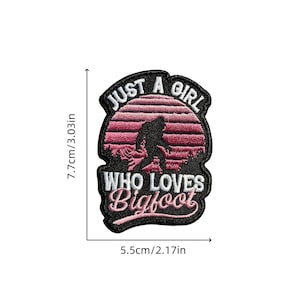 May include: Embroidered patch with the text "JUST A GIRL WHO LOVES Bigfoot". The patch features a silhouette of Bigfoot in a pink and black sunset design, measuring 7.7cm/3.03in high and 5.5cm/2.17in wide.