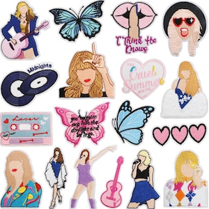 May include: A collection of embroidered patches featuring various designs. Includes a blue butterfly, a pink butterfly with text, a cassette tape with "Lover" text, a record, and several stylized figures. The patches are in various colors, including pink, blue, and black.