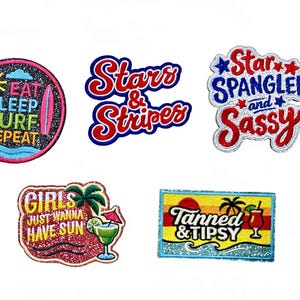 May include: A collection of glittery patches with summer and patriotic themes. Designs include "Eat Sleep Surf Repeat", "Stars & Stripes", "Star Spangled and Sassy", "Girls Just Wanna Have Sun", and "Tanned & Tipsy".