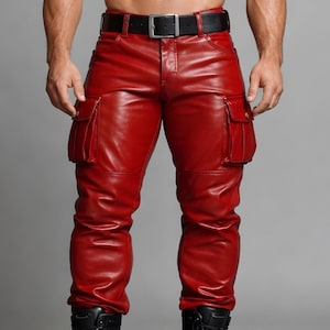 Puede incluir: Pantalones cargo de cuero rojo con dos bolsillos en cada pierna. Los pantalones tienen un cinturón negro con una hebilla plateada. Los pantalones están hechos de un material brillante y liso.