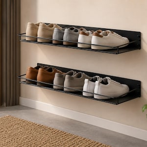 Può includere: Due mensole fluttuanti in metallo nero montate a parete, ciascuna dotata di un sottile binario di protezione. Le mensole sono disposte verticalmente e ospitano diverse paia di scarpe e sneakers casual in tonalità neutre.