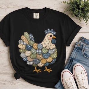 Op de afbeelding: Zwart T-shirt met een kleurrijk patchwork kippenontwerp. De kip heeft een blauwe kam, gele snavel en poten, en een lichaam gemaakt van verschillende stoffen stukken met patronen in blauw, groen en beige. Het shirt wordt gecombineerd met een blauwe jeans en witte sneakers.