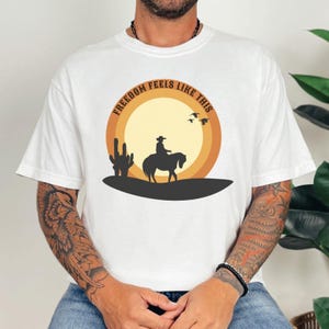 Herren T-Shirt Freedom Feels Like This – Oversized Nature Shirt mit Cowboy & Sunset | Western Outdoor Statement Shirt