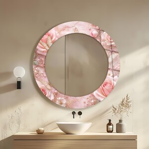 May include: A round wall mirror featuring a decorative frame with a pink marble-like pattern, light pink roses, small white flowers, scattered pearls, and gold-toned butterfly accents. The mirror surface is reflective and circular in shape.