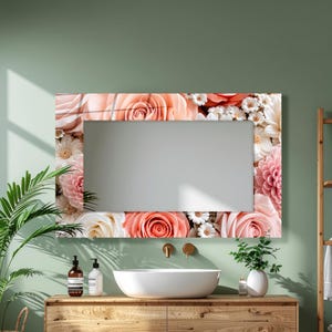 May include: A rectangular wall mirror featuring a decorative border printed with a vibrant floral pattern of peach roses, pink dahlias, and small white daisies. The reflective glass surface is framed by these dense, colorful botanical arrangements.